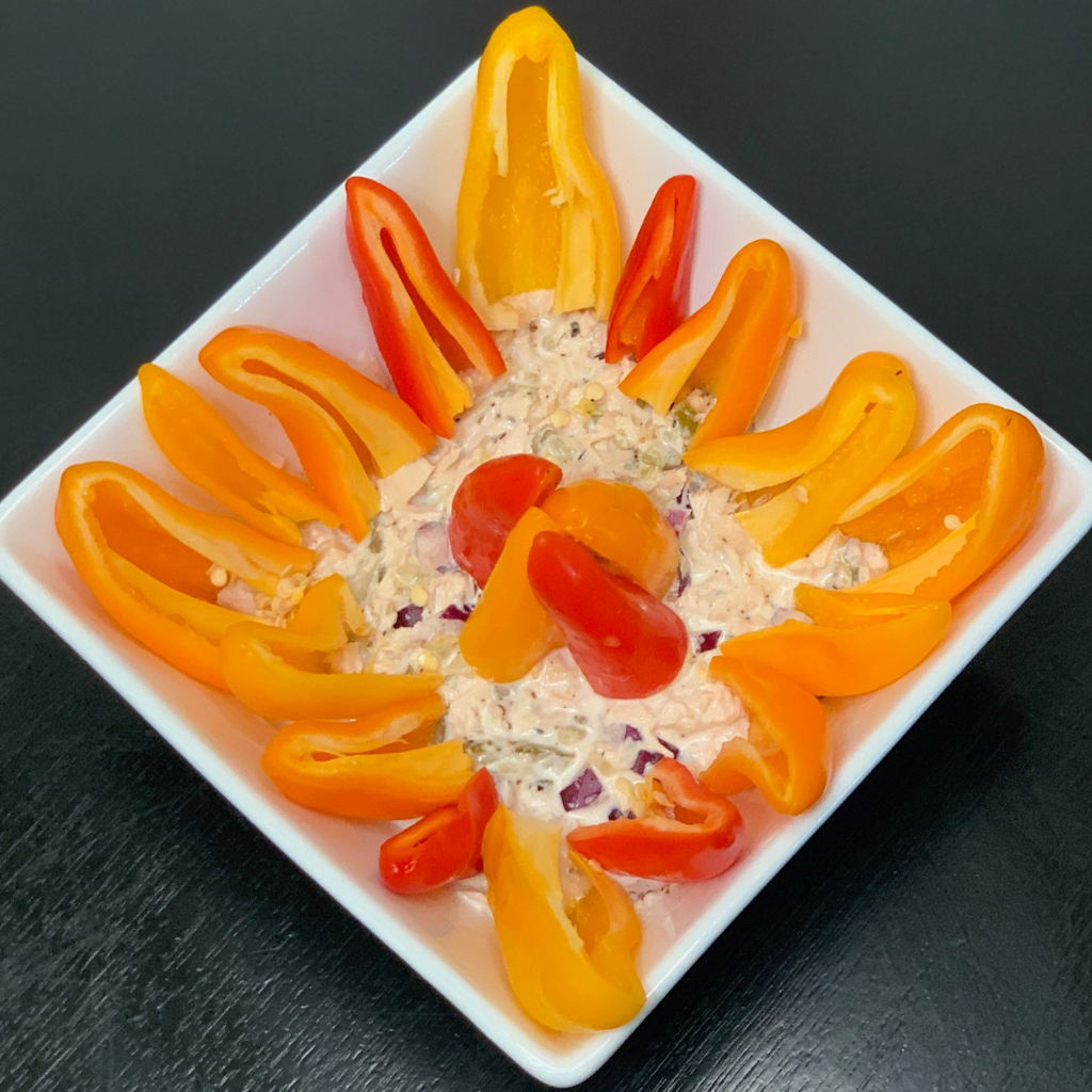 Halved sweet peppers stuffed with a salty sweet tuna mixture including: flaked tuna, mayonnaise, relish, red onion and black pepper.